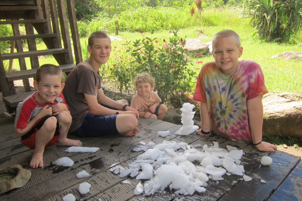 The boys playing with the "snow" on the porch