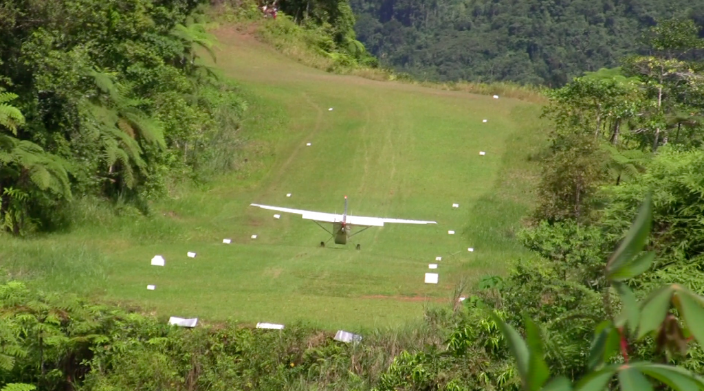 This is me landing on the airstrip a year ago. You can see it isn't the kind of place you want to be bouncing around in. In this photo the plane is just transitioning down the steepest part of the downhill. It's still traveling fast enough that it wants to float off the airstrip. It used to be that we could force it down the hill to follow the transition, but as it is now, that is a very, very difficult thing to do.