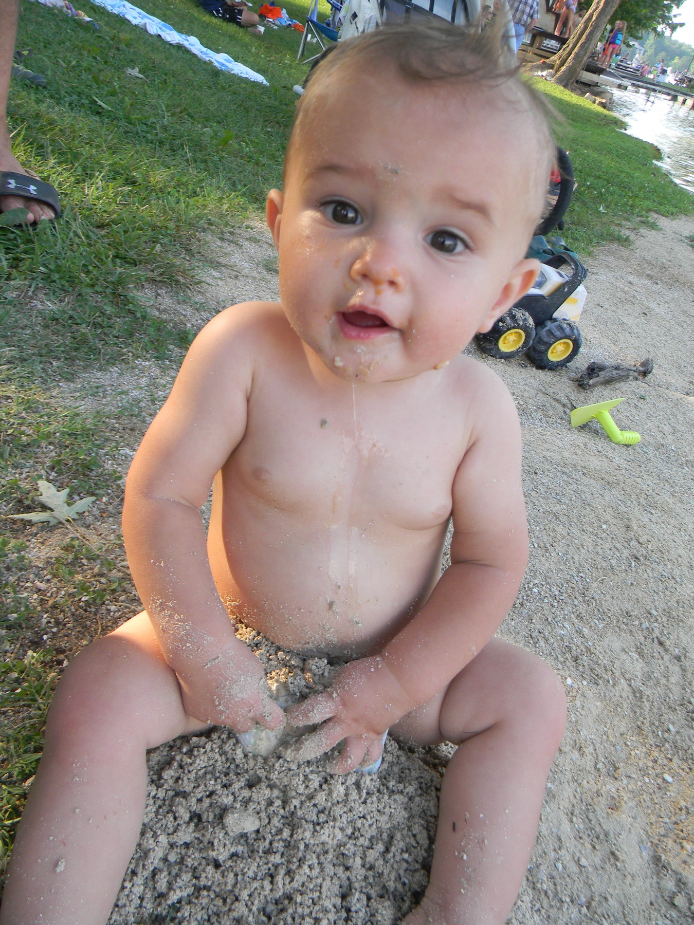 Elias enjoying (and eating) the little beach we have on campus