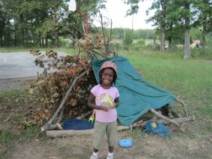 Elena in front of the "fort" made from a downed limb, shower curtain etc