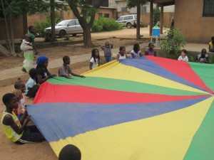 A game where a kid goes under the parachute and crawls and touches someone's feet.  That person in turn does the same thing.