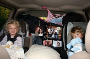 Elayne and Titus, smiling as they sit in the minivan which is packed to the roof with stuff!