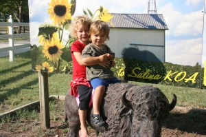 Elayne and TItus sitting on the statue of a buffalo