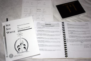 Jordan's linguistics workspace includes a Cherokee language primer, handwritten notes on how various sounds interact, a book on interpreting phonetic data, and a Cherokee New Testament.