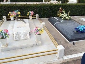 Two graves in a Mexican cemetery, covered with flowers and gifts from living relatives