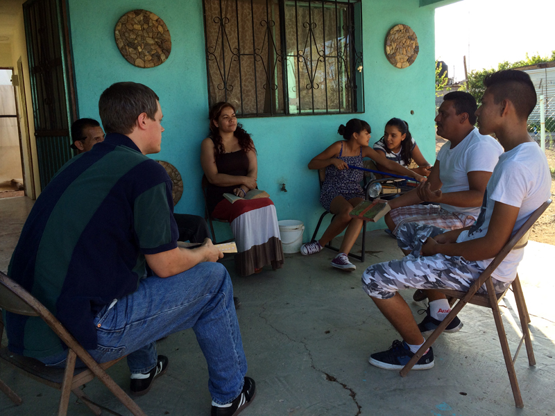 Jordan teaching from Romans 12:1-2 at a small Spanish-language Bible study