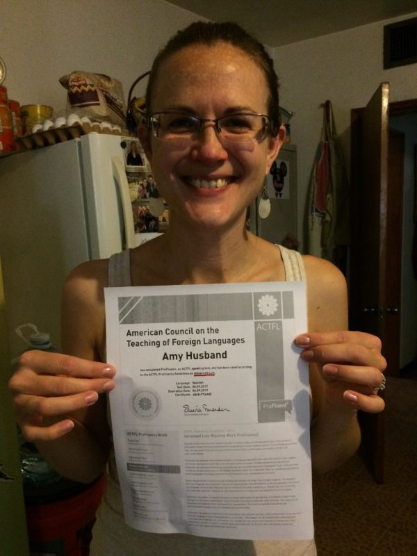 Amy, holding her certificate from ACTFL, which verifies she's reached her language goals!