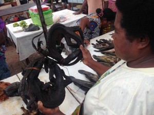 A lady selling barbecued monitor lizards at the market!