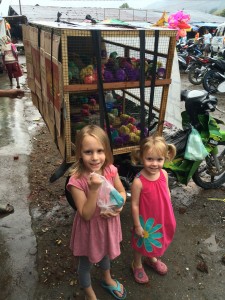 Nicole and Ella picking out colorful chicks at the market