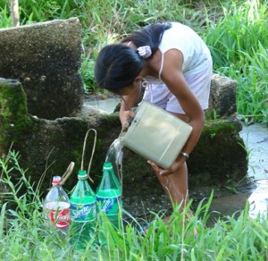 Agutaynen girl filling up her Coke and Sprite bottles with water.