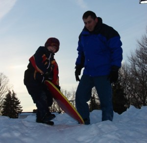 Uncle Paul helping Luke sled
